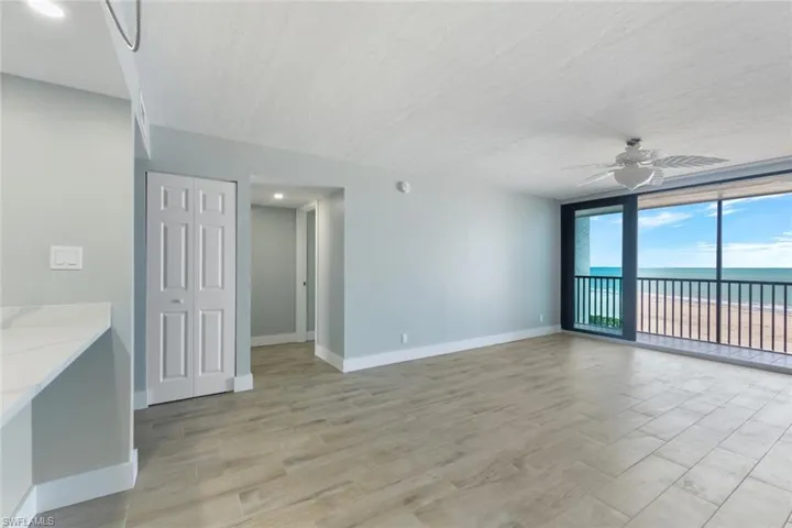 Greatoom featuring a water view, baseboards, a ceiling fan, and light wood-style floors
