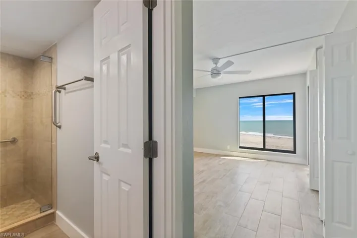 Full bathroom featuring baseboards, a stall shower, and ceiling fan