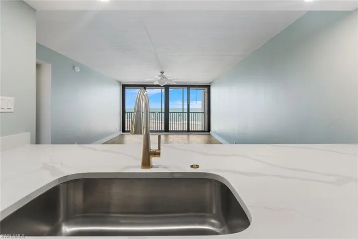 Details with light stone counters, a sink, and baseboards