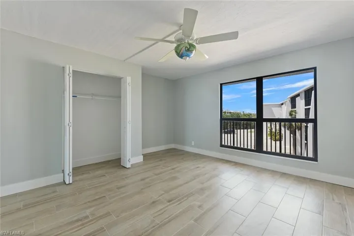 Unfurnished bedroom with light wood-type flooring, baseboards, and ceiling fan