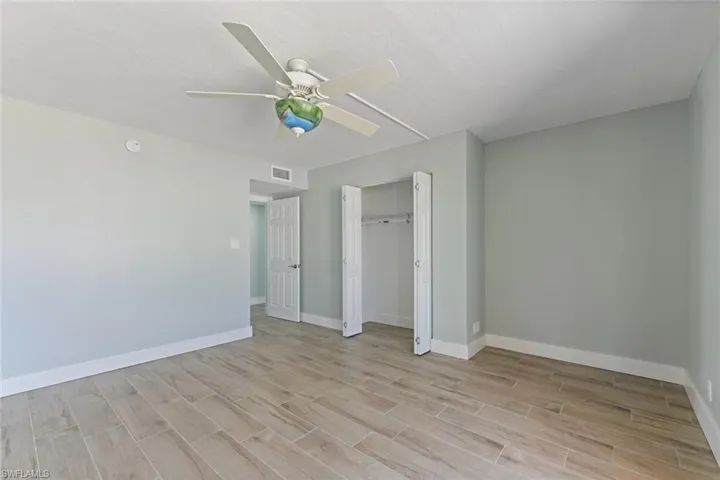 Unfurnished bedroom with visible vents, a closet, baseboards, ceiling fan, and light wood-style floors