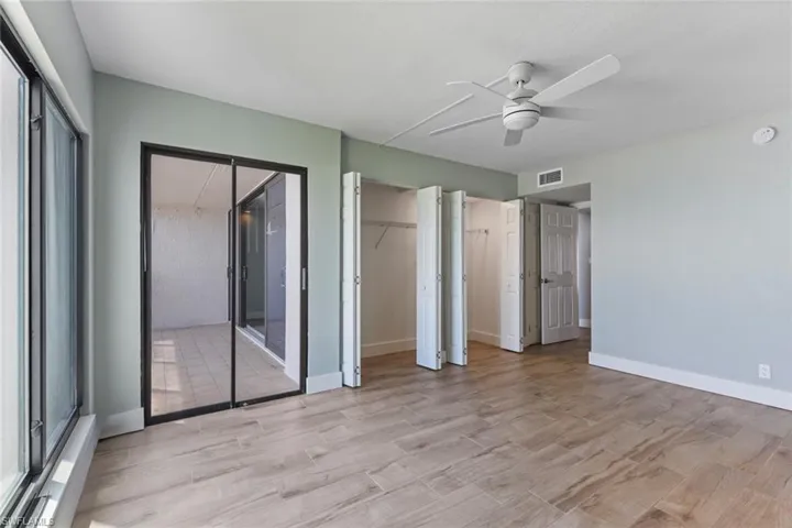 Unfurnished bedroom with light wood-style floors, visible vents, baseboards, and two closets