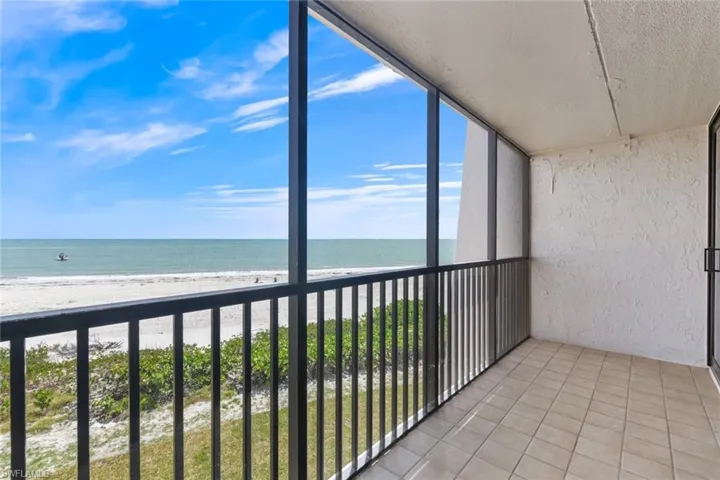 Balcony featuring a water view and a view of the beach