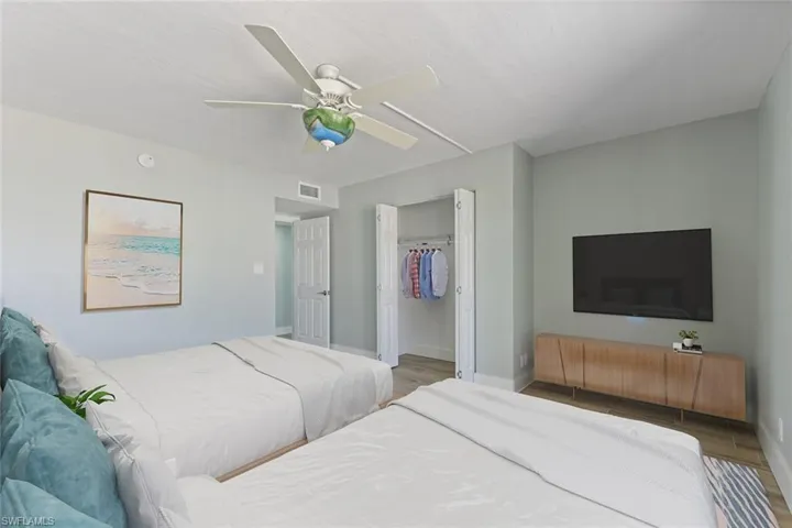 Bedroom with visible vents, baseboards, a closet, a ceiling fan, and wood finished floors