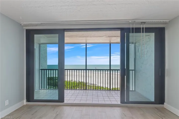Doorway to outside featuring a water view, baseboards, and wood finished floors