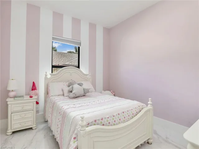 Bedroom with light marble finish flooring