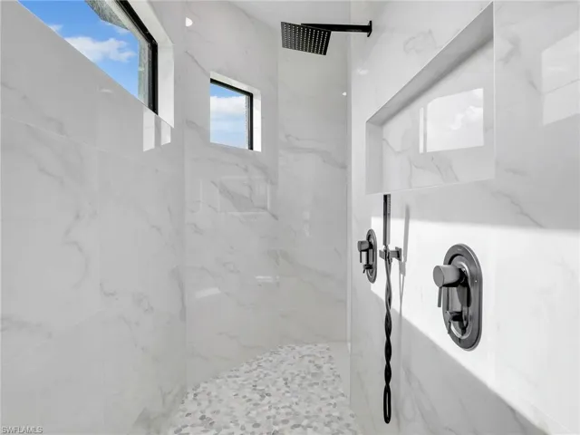 Full bath featuring a marble finish shower