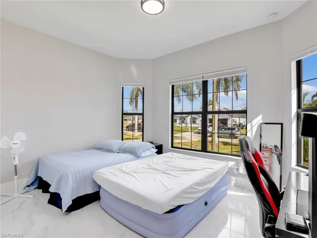 Bedroom featuring marble look tiles and a desk