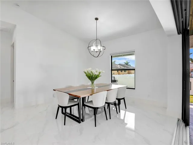 Dining area with marble finish floors and a chandelier