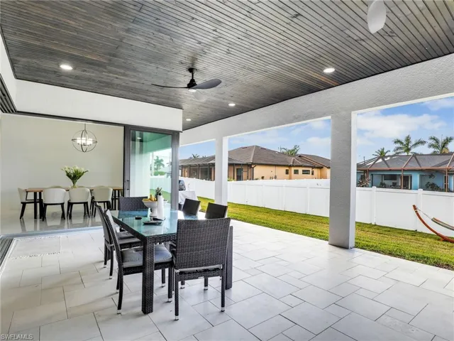 Fenced backyard featuring outdoor dining space, a ceiling fan, and a patio