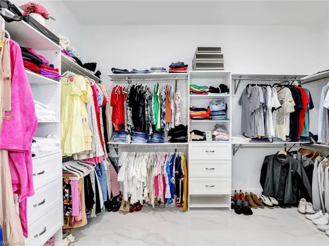 Walk in closet with marble finish floors