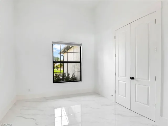 Unfurnished bedroom featuring marble tiled flooring and a closet