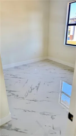 Unfurnished room with marble finish floor and baseboards