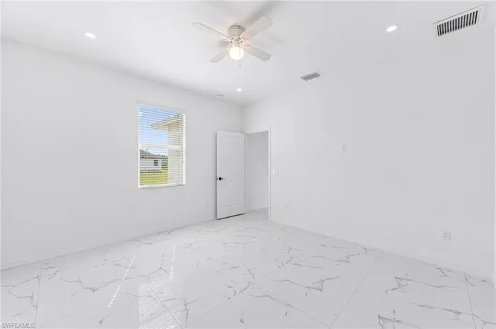 Empty room featuring a ceiling fan, recessed lighting, marble finish floor, and visible vents