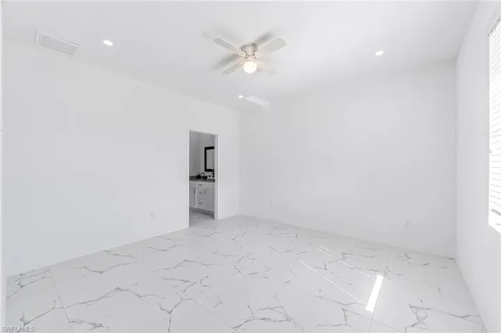 Unfurnished room featuring marble finish floor, ceiling fan, visible vents, and recessed lighting