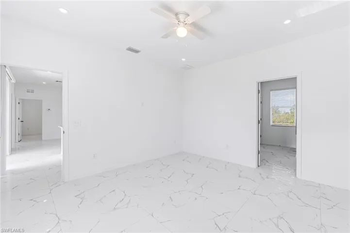 Unfurnished room with ceiling fan, marble finish floor, visible vents, and recessed lighting