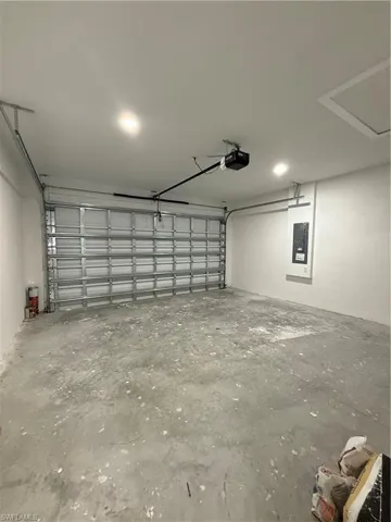 Garage with electric panel and a garage door opener