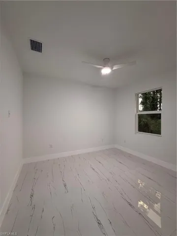 Spare room with light marble finish flooring and ceiling fan
