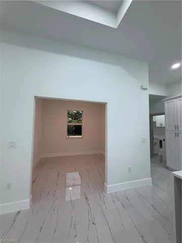 Spare room with light marble finish floors and recessed lighting
