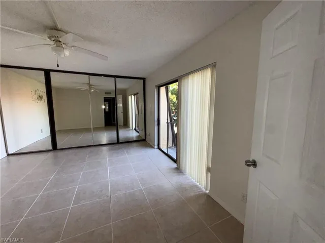 Tiled spare room featuring a textured ceiling and ceiling fan