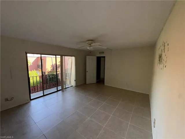 Empty room with a ceiling fan and light tile patterned floors