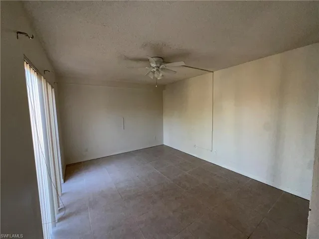 Spare room featuring a ceiling fan and a textured ceiling