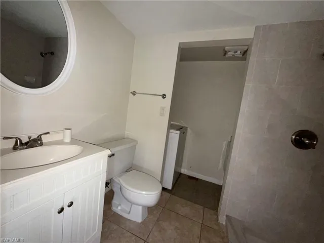 Full bathroom with vanity, light tile patterned flooring, and a shower
