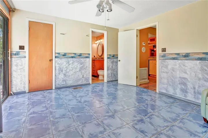 Unfurnished bedroom with tile flooring, a closet, ensuite bathroom, and ceiling fan
