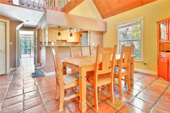Dining area featuring vaulted ceiling, wood ceiling, and light tile floors
