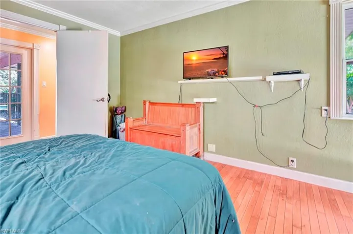 Bedroom featuring wood flooring and crown molding