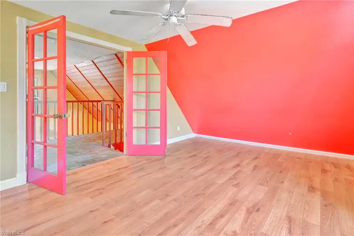 Empty room featuring ceiling fan, vaulted ceiling, and hardwood / wood-style floors