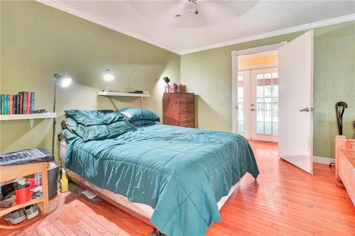 Bedroom featuring ceiling fan, ornamental molding, and hardwood / wood-style flooring