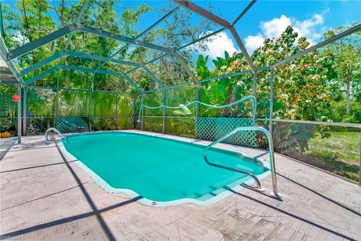View of swimming pool featuring a patio and a lanai