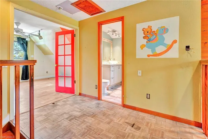 Empty room with sink, light parquet floors, ceiling fan, and a textured ceiling