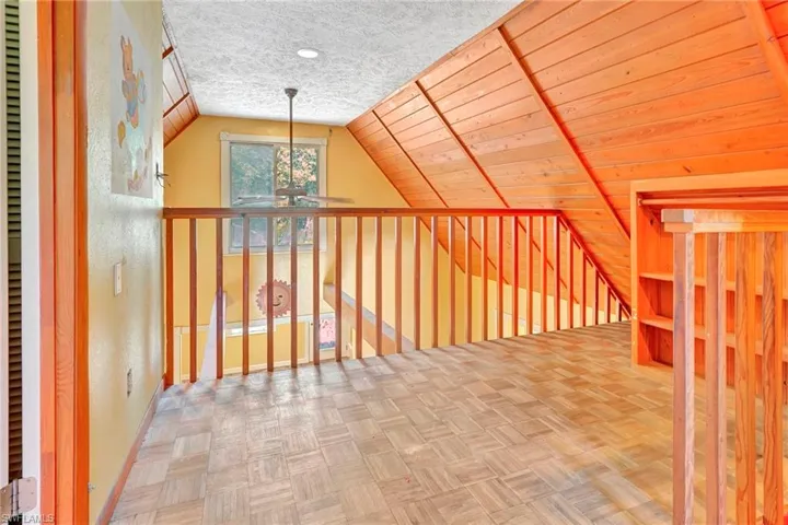 Bonus room featuring light parquet floors, a textured ceiling, lofted ceiling, and wooden ceiling