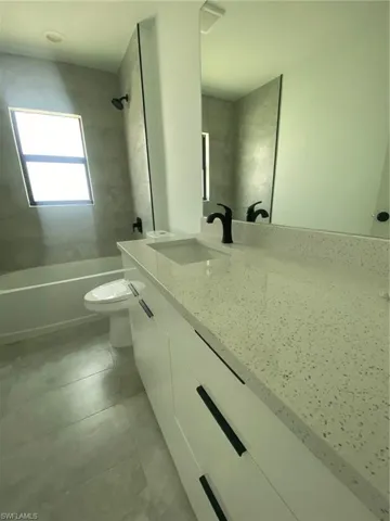 Full bathroom featuring tile patterned floors, toilet, bathing tub / shower combination, and vanity