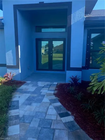 Doorway to property featuring french doors and stucco siding