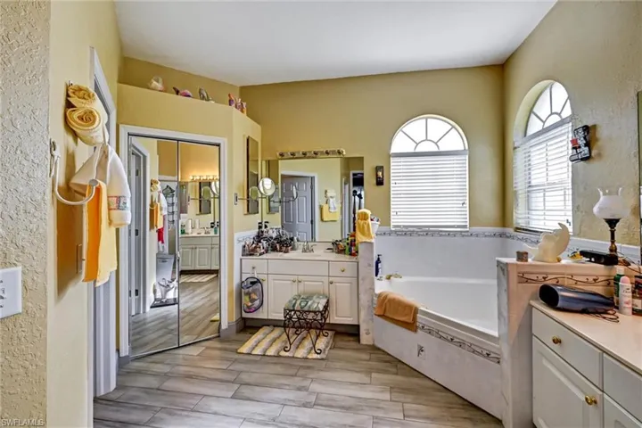 Full bath with 2 vanities, an oversized garden bathtub, and wood style tile floors