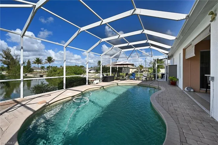 Outdoor pool featuring a sunroom, a lanai, and a patio area