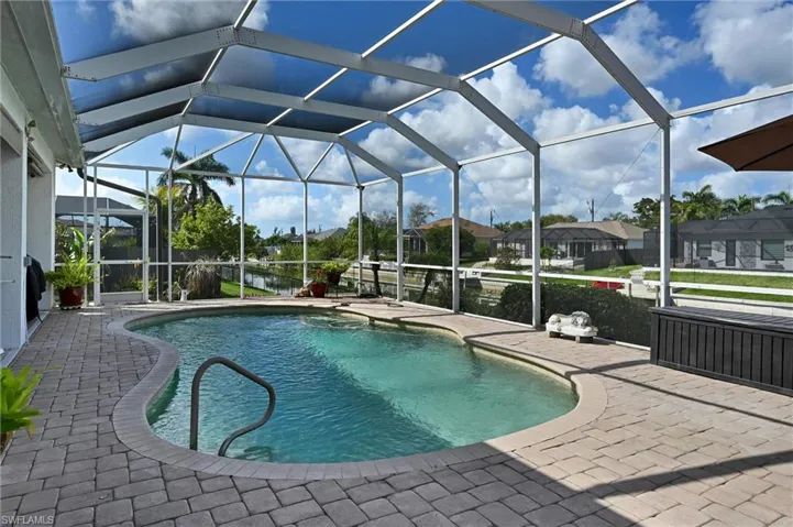 Swimming pool featuring a sunroom, a patio, and a lanai
