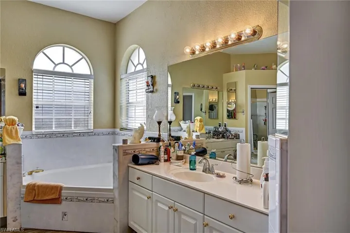 Full bath with 2 vanities, an oversized garden bathtub, and wood style tile floors