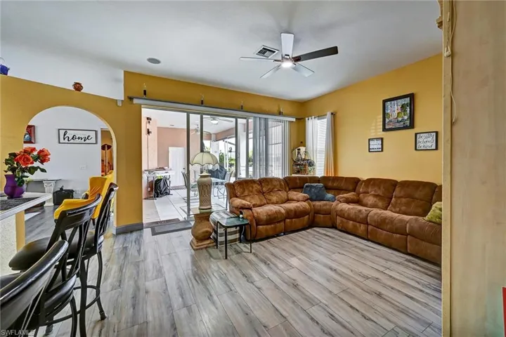 Living area featuring a ceiling fan, wood tile style flooring, and healthy amount of natural light