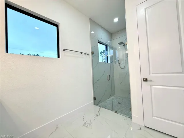 Full bathroom with a marble finish shower, marble finish floors, and recessed lighting
