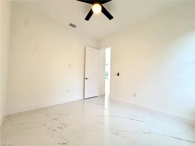 Empty room with baseboards and ceiling fan