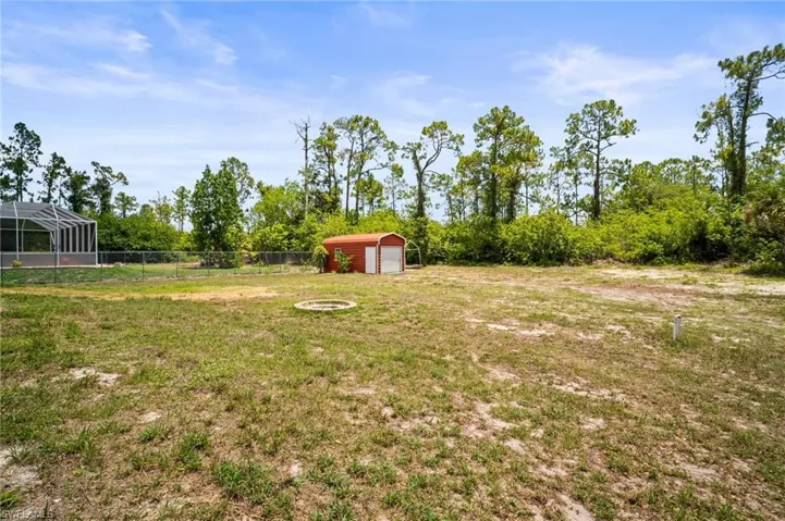 View of yard featuring a detached garage and an outbuilding