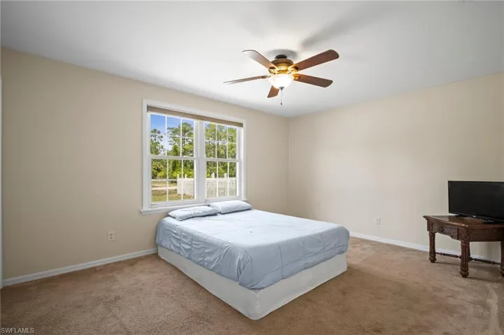 Bedroom featuring carpet, baseboards, and ceiling fan