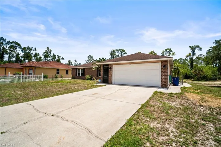 Single story home with a garage, concrete driveway, and brick siding