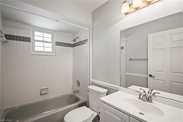 Bathroom featuring  shower combination, vanity, and toilet