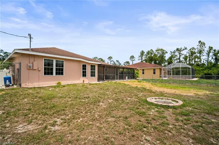 Rear view of property with stucco siding and a sunroom