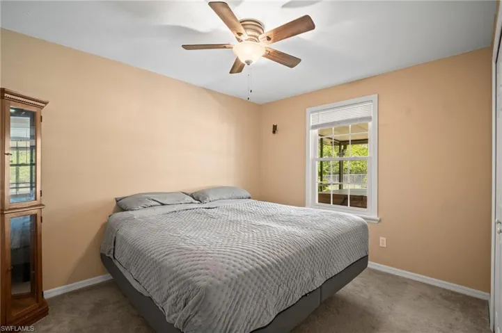 Carpeted bedroom featuring baseboards and ceiling fan